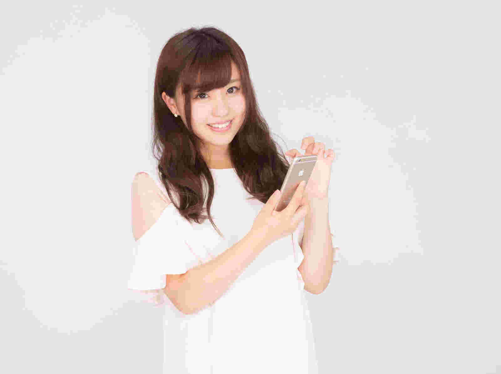 スマホを手に微笑む女性