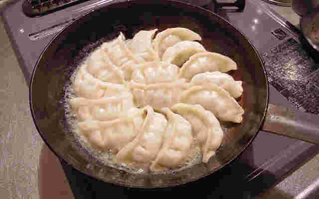 フライパンで餃子を焼いている様子