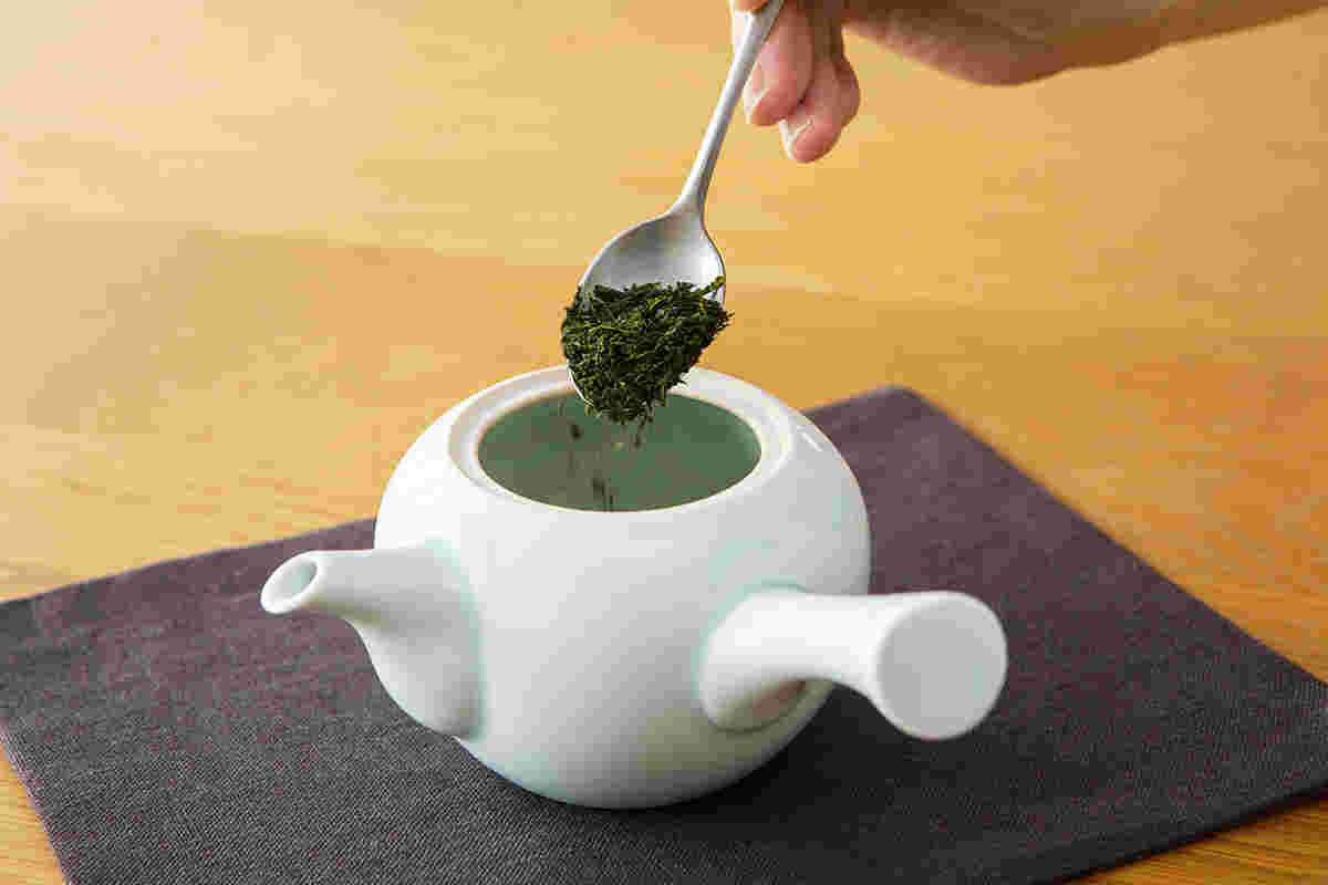 ティースプーンで急須に煎茶の茶葉を入れているところ