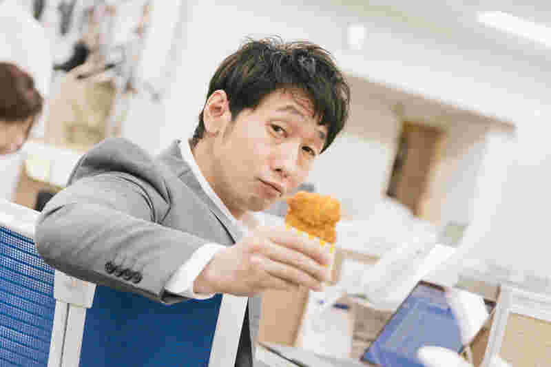 フライドチキンを片手に持っている男性