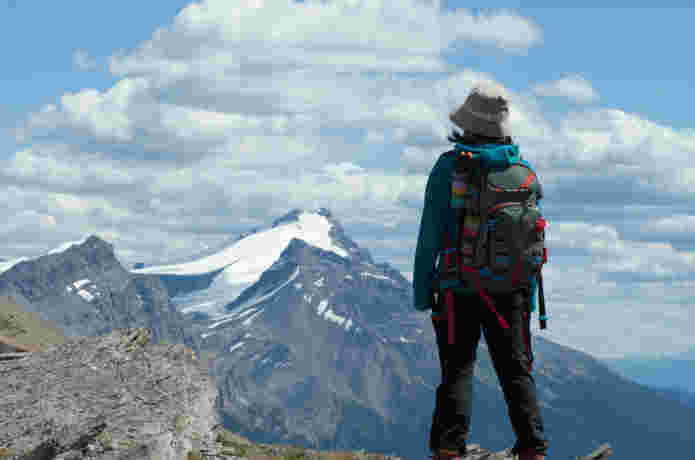 登山の頂上から山々を眺める女性
