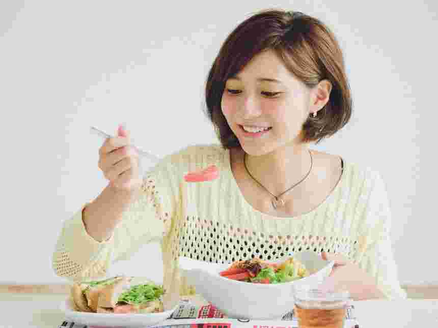 トマトを口に入れようとしている女性