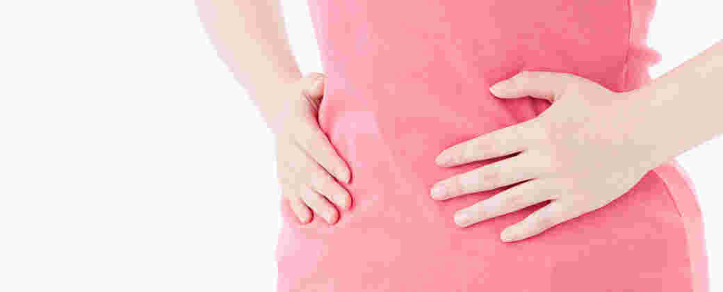 女性が手でお腹をおさえている