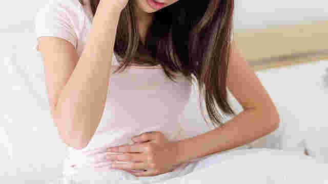 便秘が続いてお腹をおさえている女性