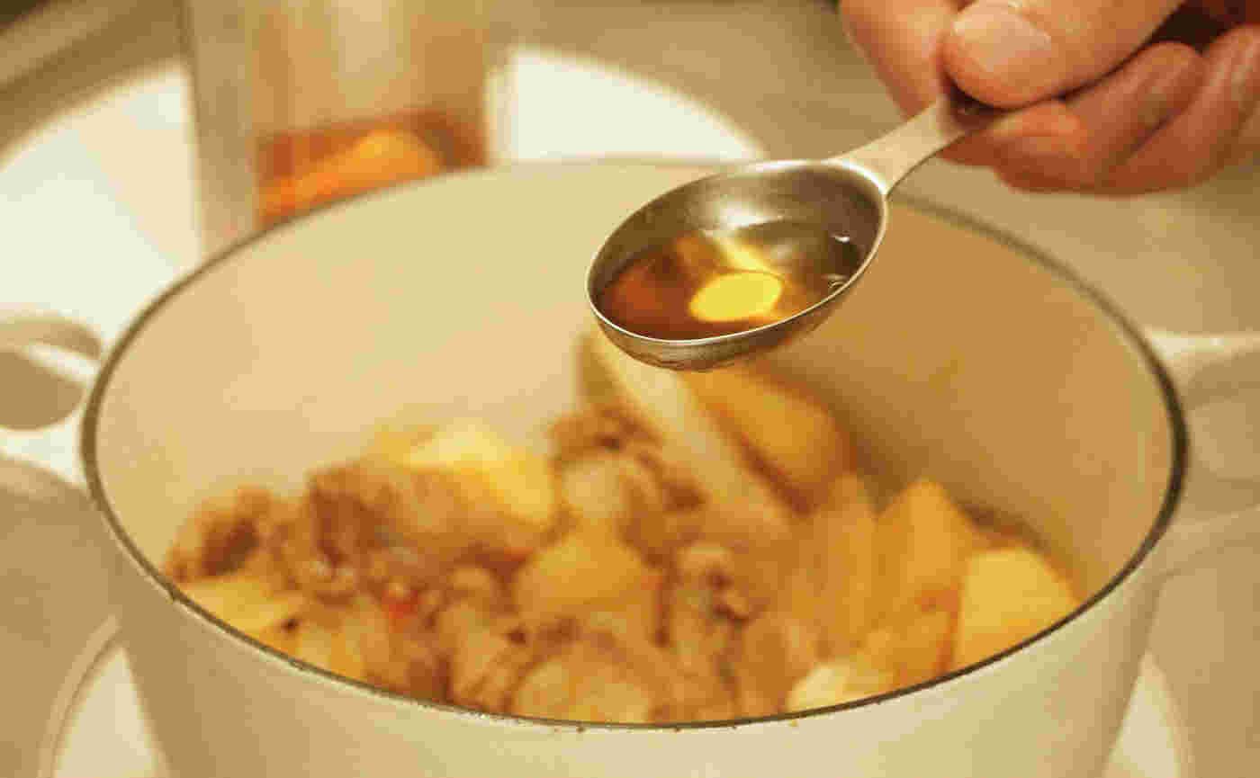みりんを肉じゃがに入れている