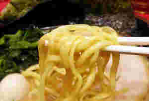 家系ラーメンの麺を箸で持ち上げている様子