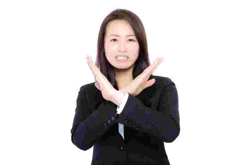 女性がダメというジェスチャーをしている