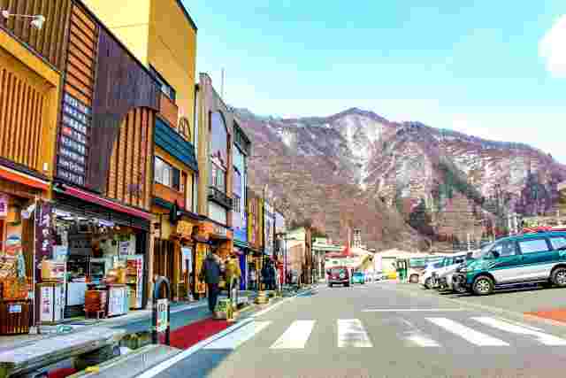 雪のかかる山の近くのお土産屋さん