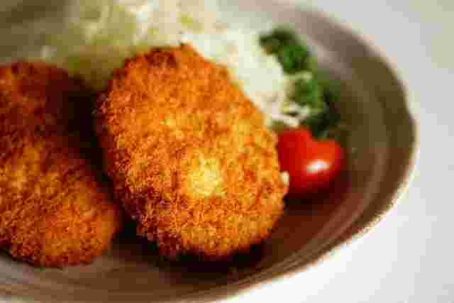 野菜の添えられたコロッケ2つ