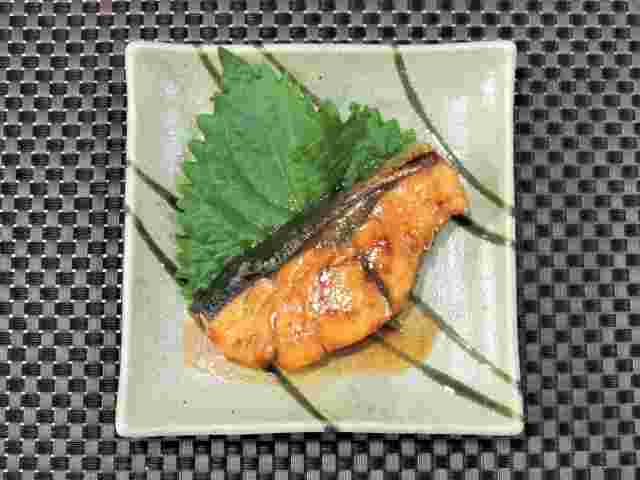 四角いお皿にシソの添えられたブリの照り焼き