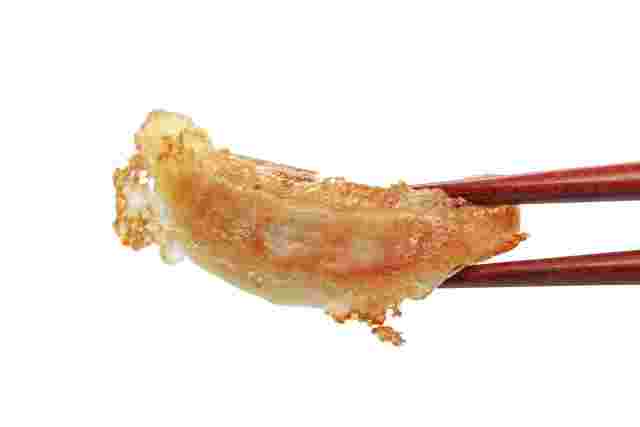 餃子を箸で掴んでいる