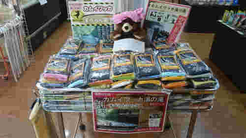 カゴテナに並べらている黒い靴下の上にかわいいクマさんのぬいぐるみが置かれている店内