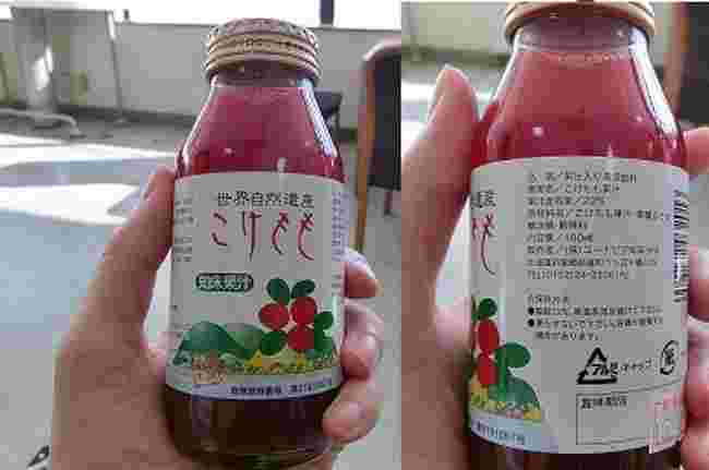 手にもった小さめのビンジュースの表と裏がみえる