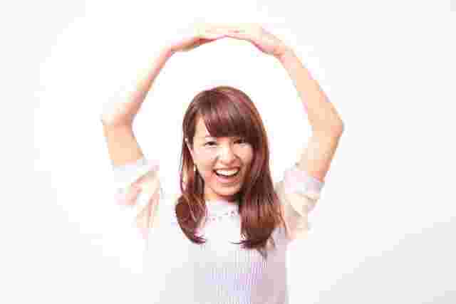 腕で丸を作る女性