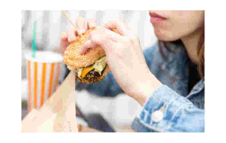 ハンバーガーを食べようとしている女性