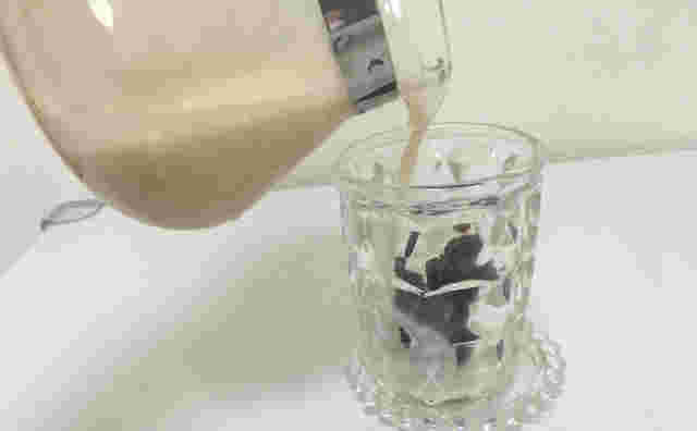 ホットミルクをグラスに注いでる
