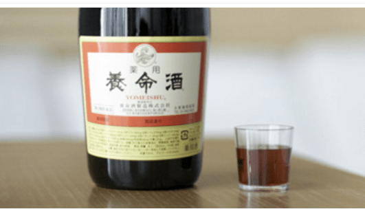 薬用養命酒の瓶とグラスに入れた養命酒