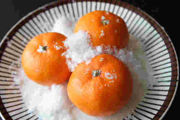 雪の上にみかんが3つのっている