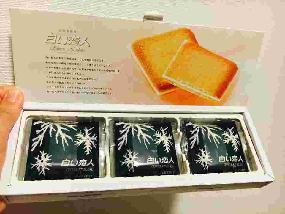 白い恋人のパッケージを開けている