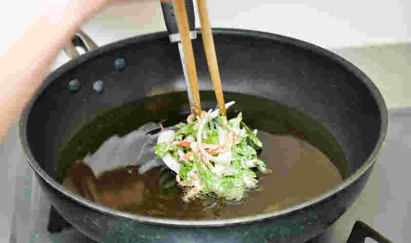 かき揚げを油に入れるところ