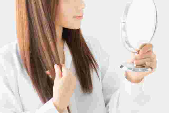 髪の毛の調子を確認する女性