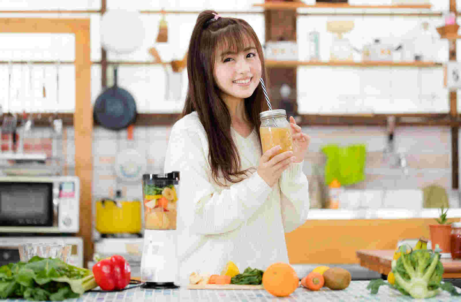 にっこり笑顔でスムージーを飲む女性