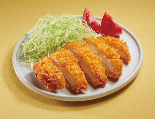 お皿に盛られたチキンカツとキャベツの千切りとトマト