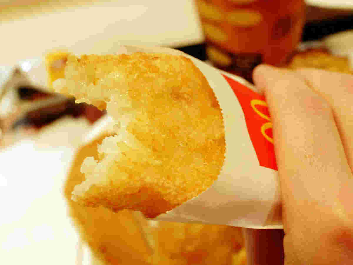 食べたあとのあるハッシュドポテトを手に持っている