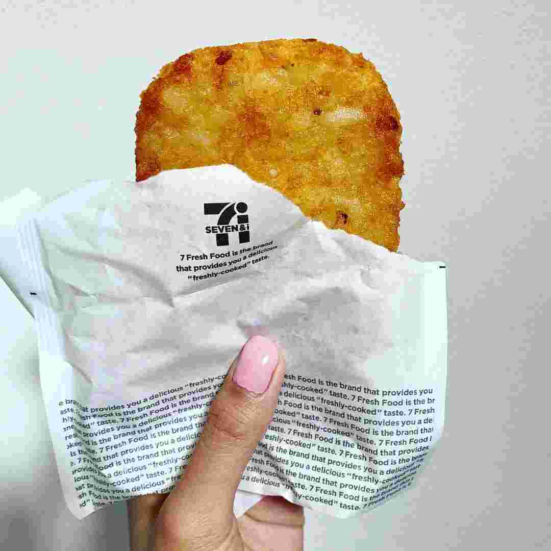 油が手につかにような紙を持って、紙のなかにハッシュドポテトが半分でている