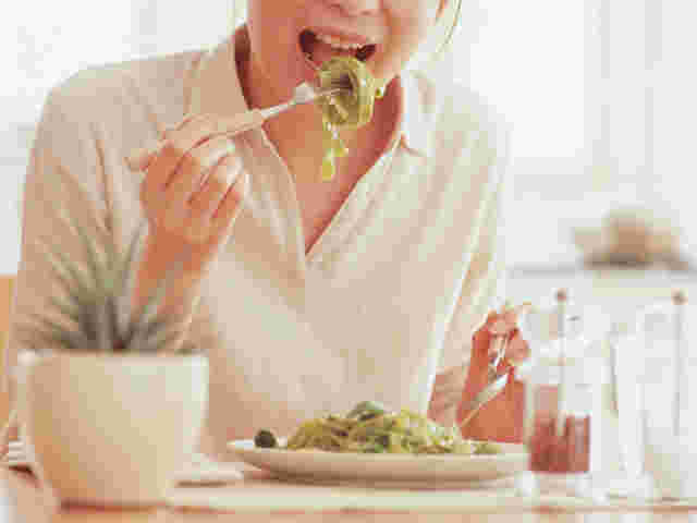 パスタを食べる女性の上半身