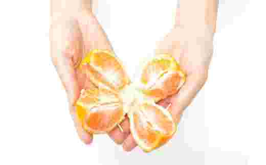 手のひらでみかんを割っているところ