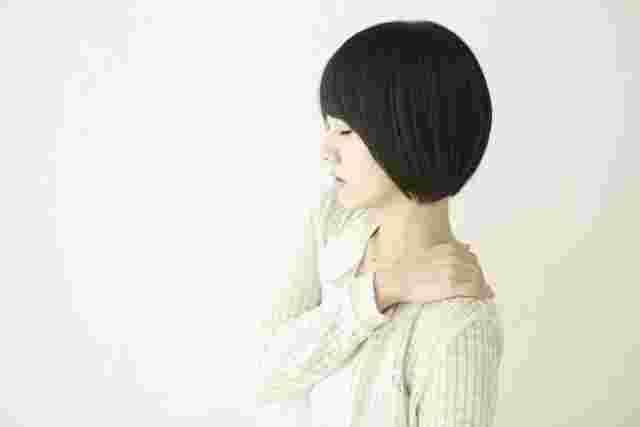 肩に手をあててつらそうな女性