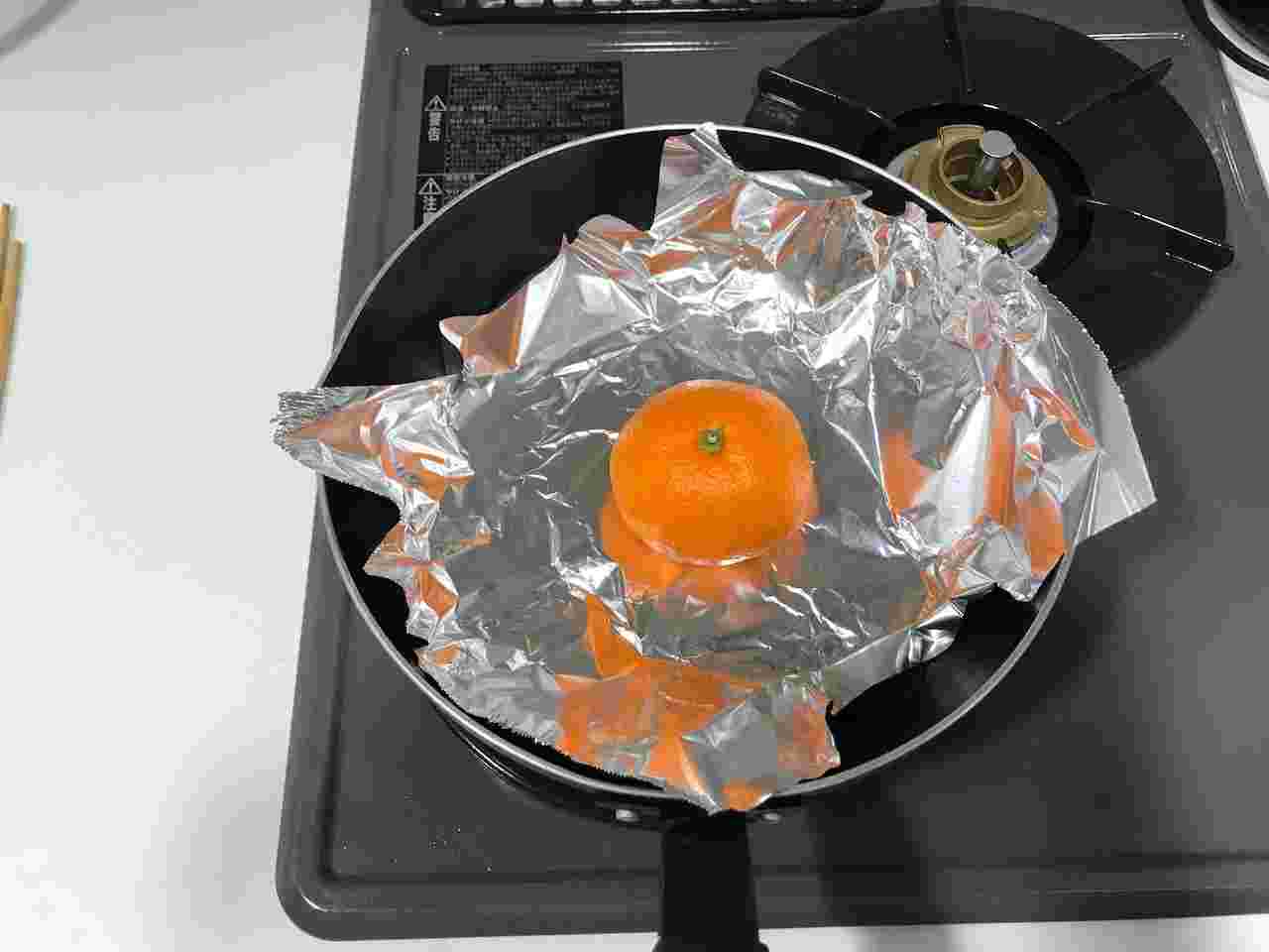 フライパンでみかんを焼いている画像
