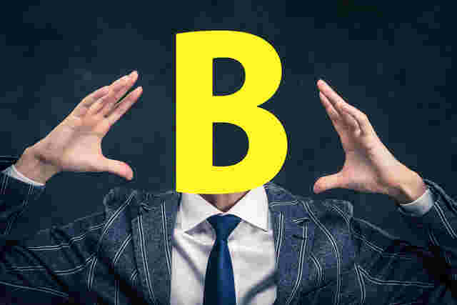顔がBという文字になったスーツ姿の男性