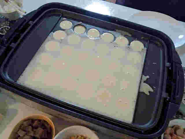 たこ焼き器いっぱいに生地が入っている