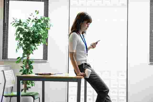 オフィスでスマホを操作する女性