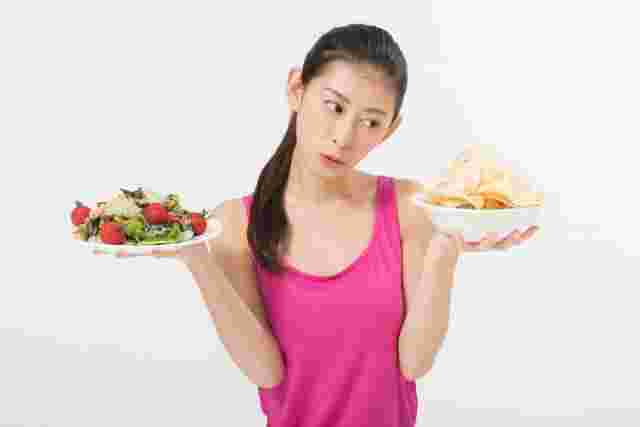サラダとスナックを持つ女性