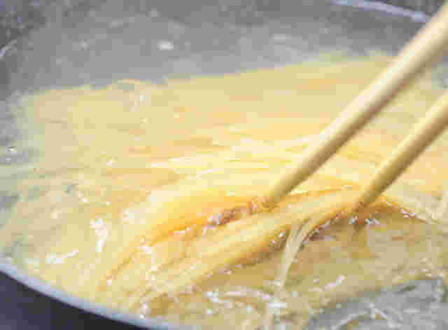 大きな鍋で麺を茹でている様子