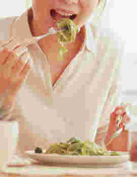 パスタを食べる女性の上半身