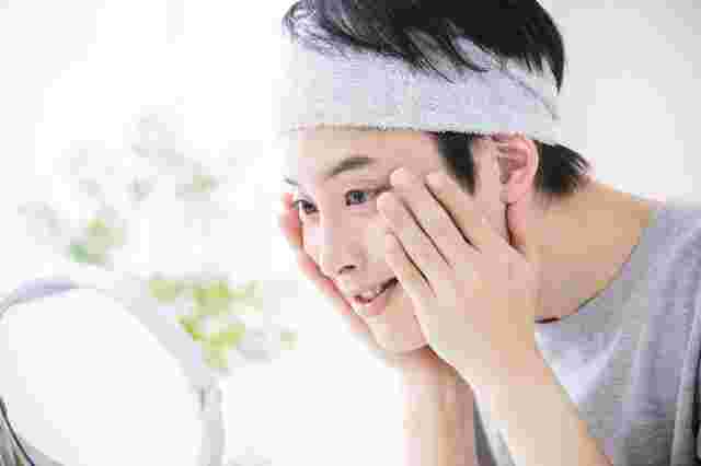 鏡を見つめる綺麗な肌の男性