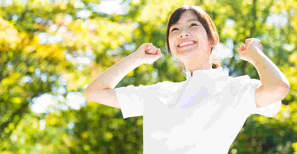笑顔で両手を上げようとしている女性