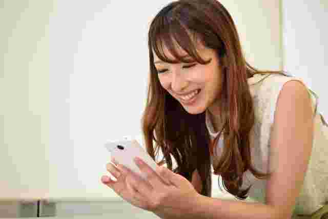 笑顔でスマホを操作する女性