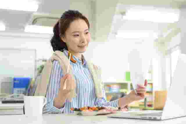 職場でコンビニ弁当を食べる女性