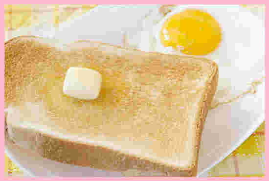 トーストの上にのったマーガリンのかたまりと目玉焼き