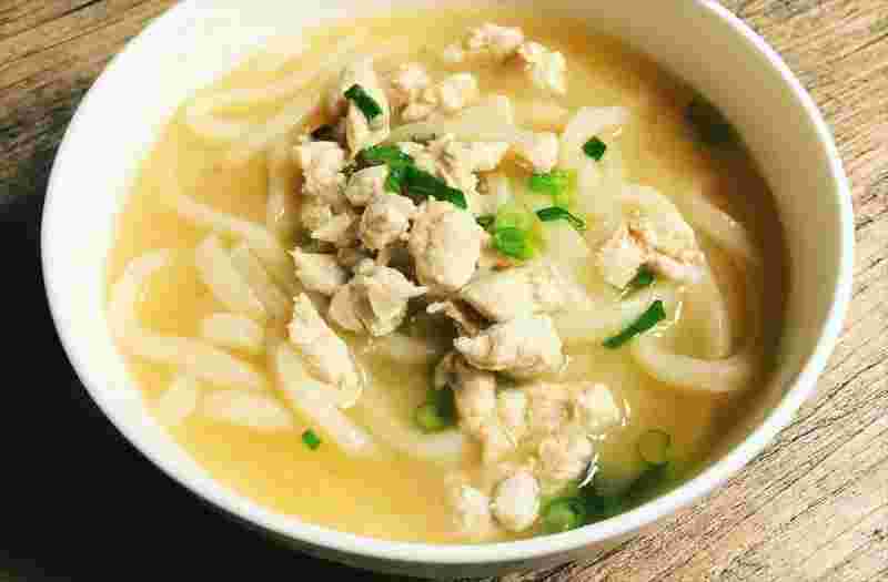 丸い大きめのうどん茶碗に、うどん、肉、子ネギ、スープが入っていて美味しそう