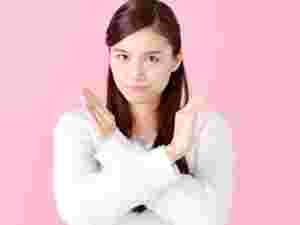 腕でバッテンポーズをしている女性