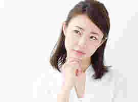 手を顎に当て考えこむ女性