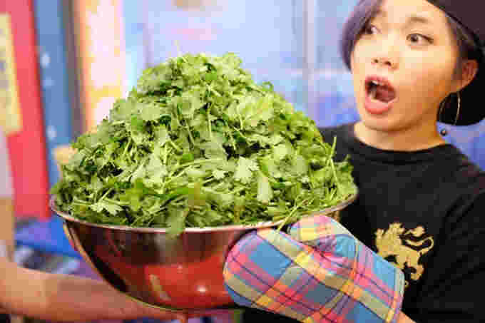 大量のパクチーを持つ女性の画像