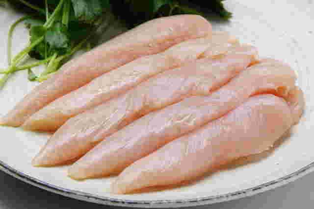 丸いお皿に野菜と複数の鶏のささ身の生肉が綺麗に並べられている