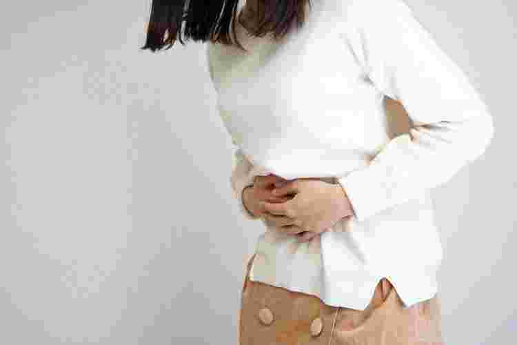 お腹をおさえている女性